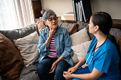 Senior woman explaining her pain to nurse at nursing home
