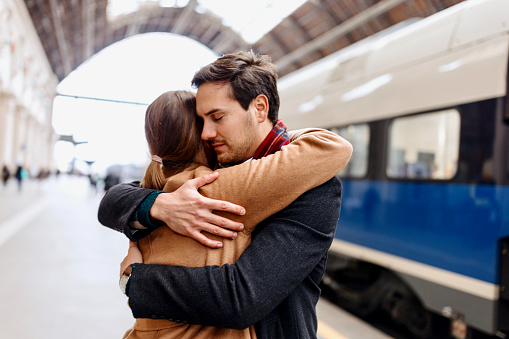 Couple parting at a train station. Long distance relationship, couple at train station