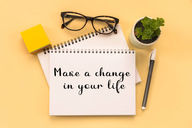 istock Make a change in your life Text written on notepad page, glasses, pen, stationery on yellow background. conceptual image 1458608793