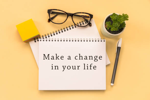 istock Make a change in your life Text written on notepad page, glasses, pen, stationery on yellow background. conceptual image 1458608919