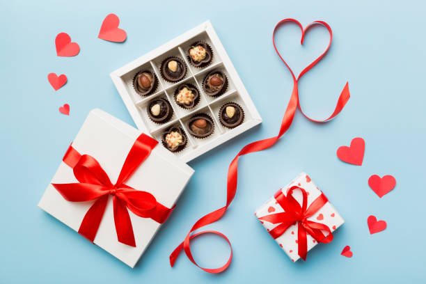 delicious chocolate pralines in box for valentine's day. heart shaped with gift box of chocolates top view with copy space - valentines day candy carnation chocolate candy imagens e fotografias de stock