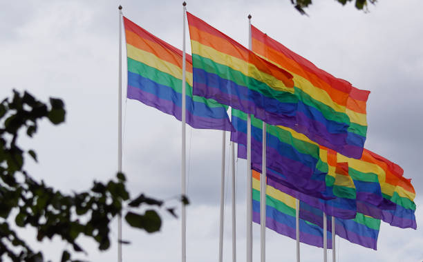 istock Low angle view of rainbow flags against sky 1458609497