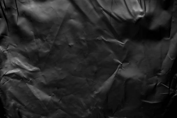 istock transparent plastic bag film wrap overlay texture on black background 1458612684