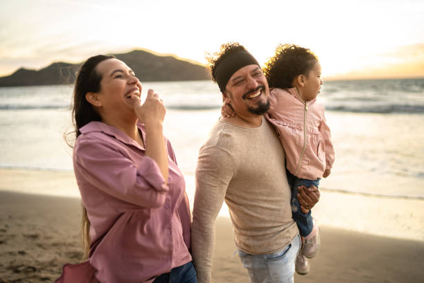 istock Father having fun with her daughter while walking on the beach 1458617371