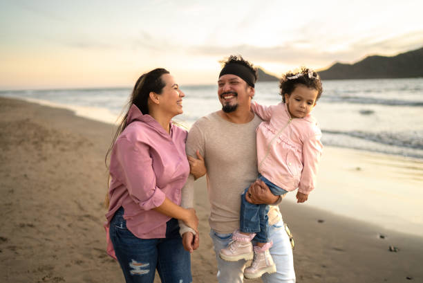 padre divirtiéndose con su hija mientras camina por la playa - family beach vacations travel fotografías e imágenes de stock