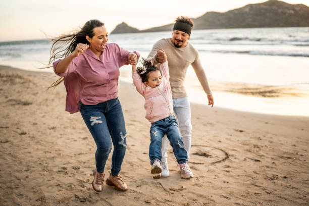 istock Parents playing with their daughter on the beach 1458618119
