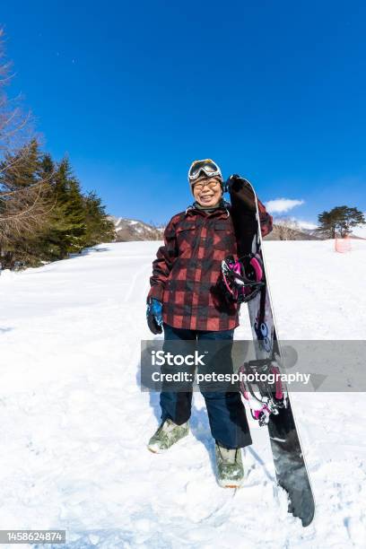 A Young At Heart Cheerful Senior Snowboarder Woman With Her Snowboard Stock Photo - Download Image Now