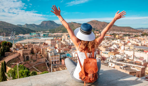 Happy woman traveling looking at panoramic city view- Cartagena and Roman Amphiteater- Murcia province in Spain - fotografia de stock