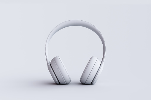 Silver metallic white wireless headphones in the air isolated on white background. Trendy minimal music device flying levitation concept of accessories. New technologies. Closeup high resolution