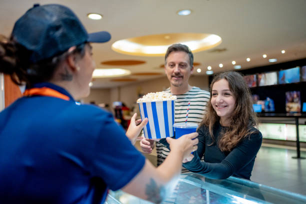 Attendant delivering popcorn to customers