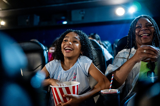 Excited girl watching movie in cinema