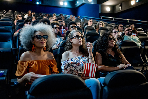 Mature female friends watching 3D movie at cinema