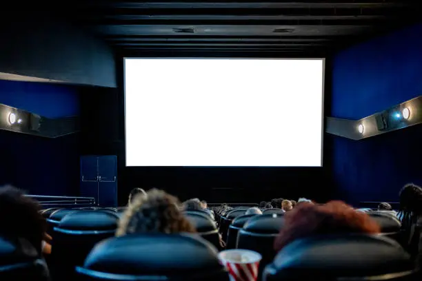 People watching at the cinema, white screen