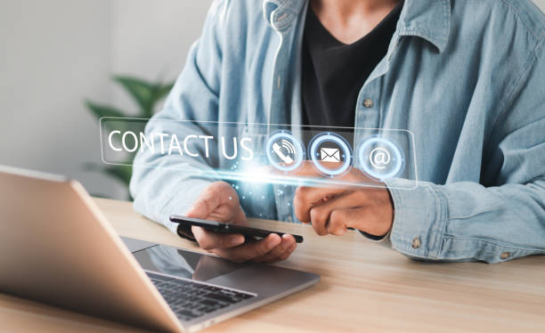istock Businessman using laptop pc with contact icons on virtual interface. searching web, browsing information, Contact us or Customer support hotline people connect. 1458646373