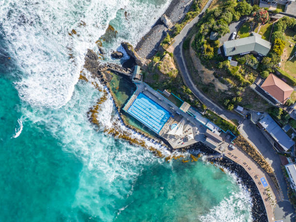Beautiful high angle bird's eye aerial drone view of a hot salt water pool and the ocean in St Clair, a beachside suburb of Dunedin, the second-largest city in the South Island of New Zealand. stock photo