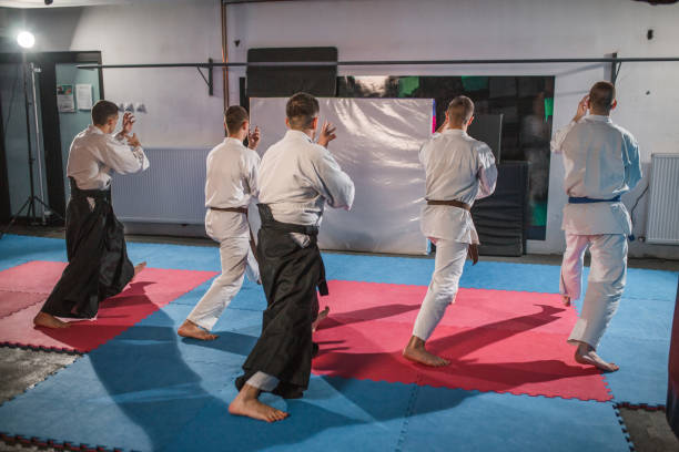 istock Back view of a small group of fighters learning self-defense from an aikido trainer 1458655914