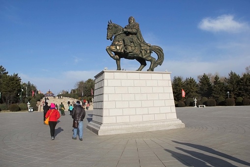 Ordos,China - November 11, 2017 : people walking under the statue of Genghis Khan to go to the Mausoleum of Genghis Khan
