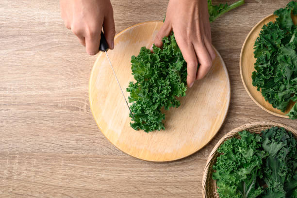 istock Green Kale or leaf cabbage cutting on wooden board, Healthy vegetable, Table top view 1458662663