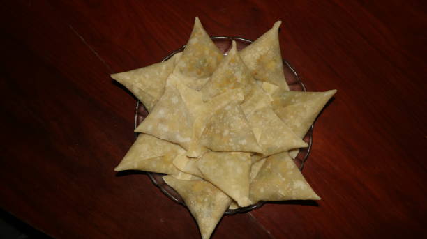 istock Uncooked frozen samosa in plate on wooden table isolated image 1458662669