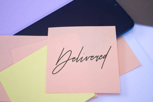 istock Delivered. Text on adhesive note paper. Event, celebration reminder message. 1458662782