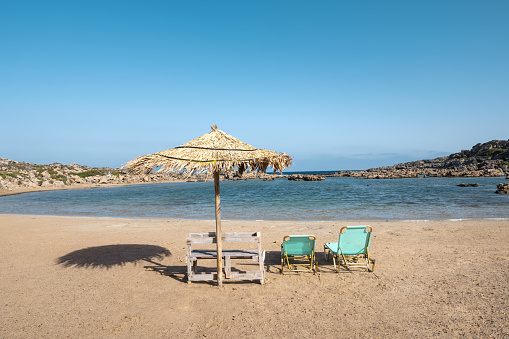 Two sunbeds on Aspri Limni beach. Crete island, Greece.