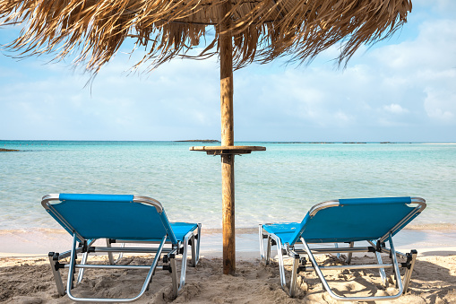 Empty empty sunbeds in the early morning on the Elafonissi beach. Crete island, Greece.