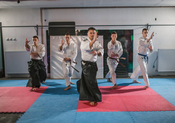 istock Front view of a small group of fighters learning self-defense from an aikido trainer 1458669866