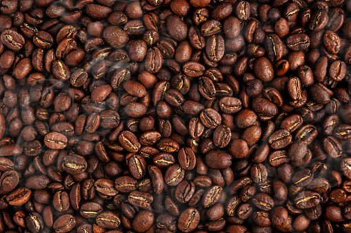 Coffee beans, food background texture and freshly roasted arabica coffee beans with smoke, top view horizontal banner