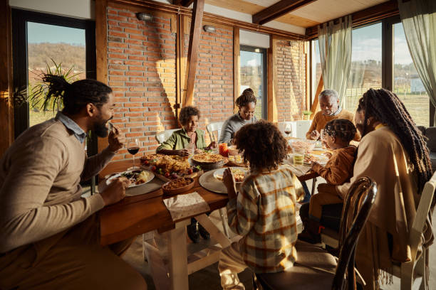 istock Black multi-generation family having a meal at dining table. 1458676836