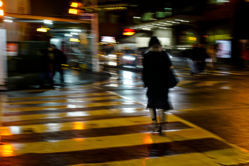 A woman on a pedestrian crossing in motion blur