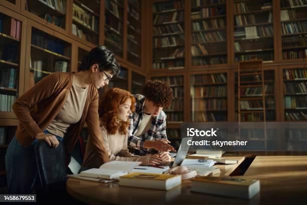 Group Of High School Students Using Laptop In Library Stock Photo - Download Image Now