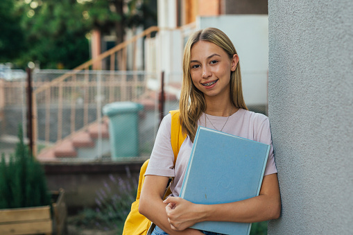 caucasian student posing outdoor holding book