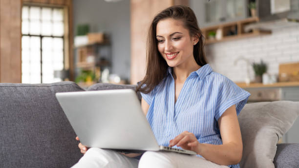 istock Woman shopping online at home using laptop 1458681502