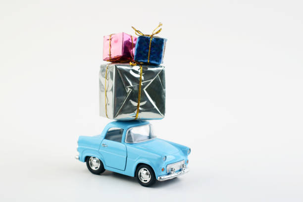 istock Toy car delivers a gift box for a holiday on a white background. 1458683088