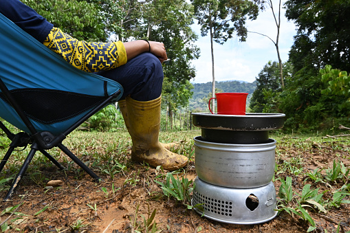Man relaxing over a cup of coffee in a pristine rainforest