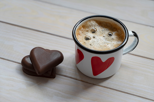 Heart shape chocolate and coffee on wood