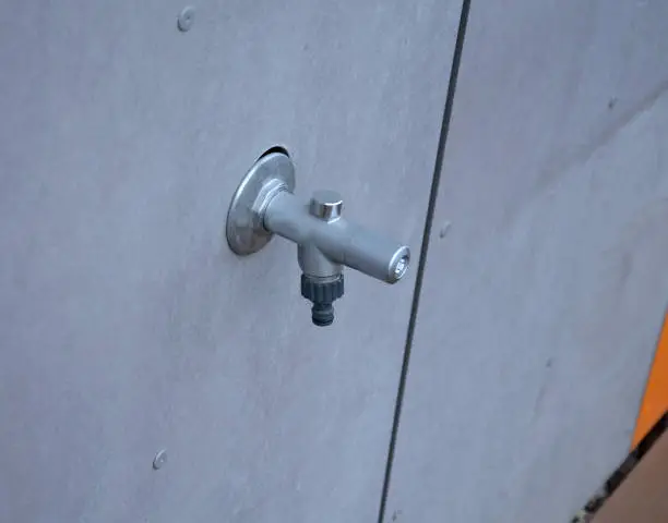 Photo of non-freezing water tap with automatic discharge of accumulated water from the pipe. it does not freeze and it is possible to use water on the facade of house even in winter and frost.orange stripe