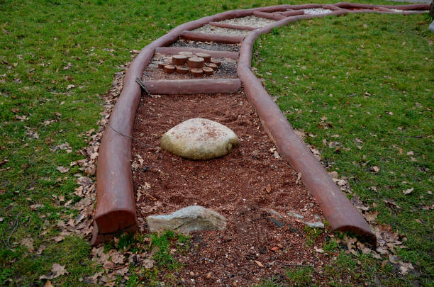 Tactile path for bare feet awakens the senses and uneven endings on the feet alternating different materials wood stone gravel sand bark in a park environment, sensoric, red, bent, curved, log Tactile path for bare feet awakens the senses and uneven endings on the feet alternating different materials wood stone gravel sand bark in a park environment, sensoric, red, bent, curved, log, tactile ivy tree bark wood stock pictures, royalty-free photos & images