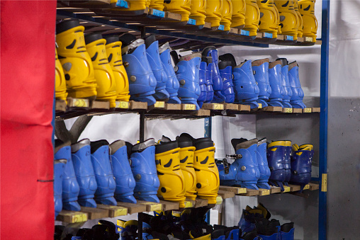 Ice skates of different sizes stored on shelves. Temporary skating installed for Christmas holidays