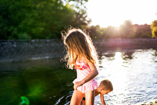 Beautiful boy and girl having fun on a river during hot summer day.