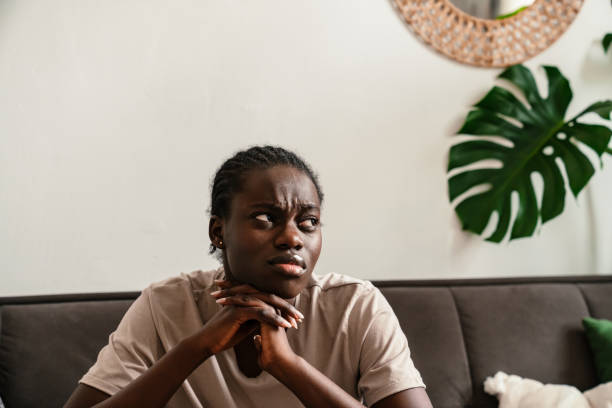 istock African american woman expressing sadness while sitting on sofa 1458694569