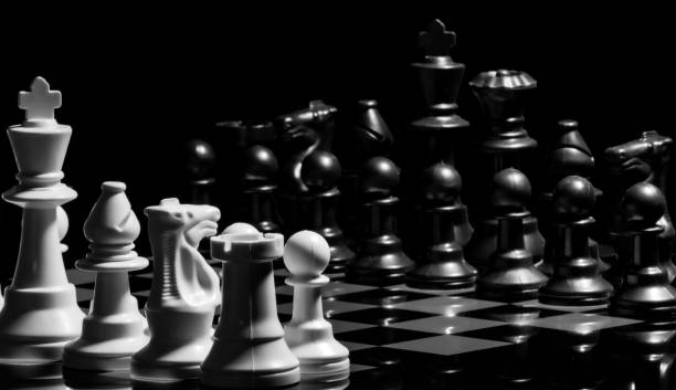 istock Close up of Chess pieces on a reflective mirror board surface wi 1458695651
