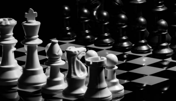 istock Close up of Chess pieces on a reflective mirror board surface wi 1458695711