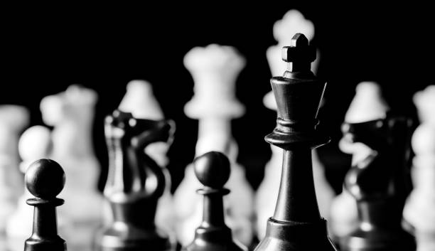 istock Close up of Chess pieces on a reflective mirror board surface wi 1458696281