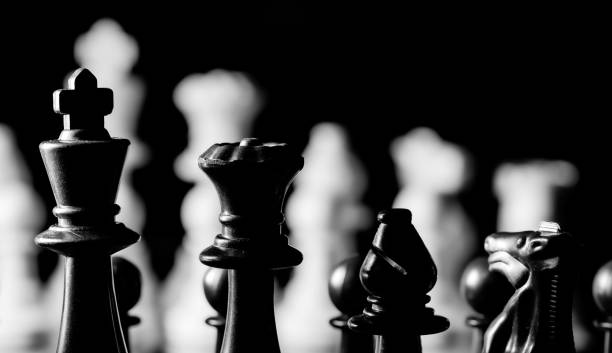 istock Close up of Chess pieces on a reflective mirror board surface wi 1458696586