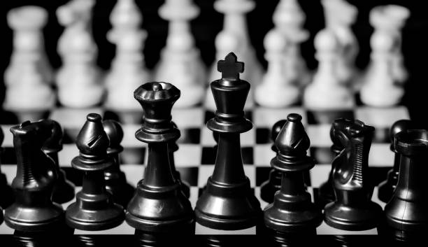 istock Close up of Chess pieces on a reflective mirror board surface wi 1458697211