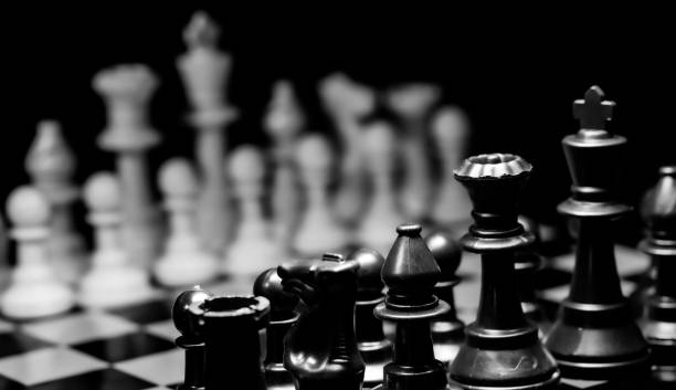 istock Close up of Chess pieces on a reflective mirror board surface wi 1458697232