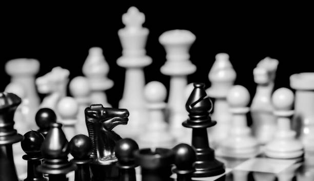 istock Close up of Chess pieces on a reflective mirror board surface wi 1458697952