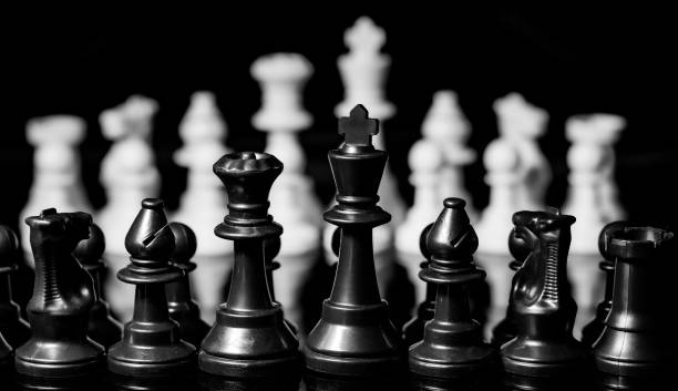 istock Close up of Chess pieces on a reflective mirror board surface wi 1458697992