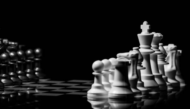 istock Close up of Chess pieces on a reflective mirror board surface wi 1458698081